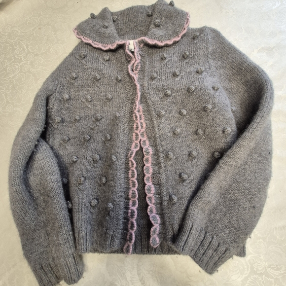 Gray knit  popcorn-stitch baby cardigan with a pink scalloped trim.  - Picture 2 of 6